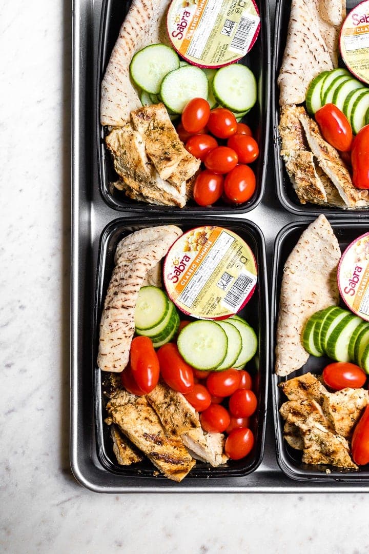 Chicken hummus bistro boxes packed with cucumber, cherry tomatoes, and a mini pita.