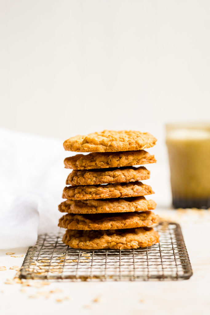 A stack of crisp oatmeal cookies on a vintage cooling rack.