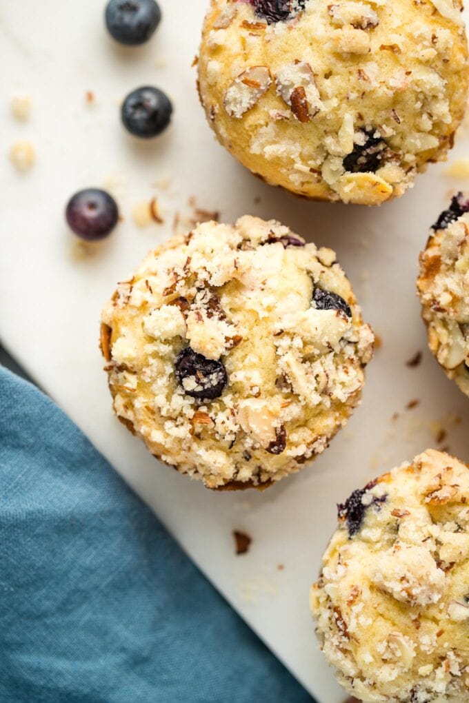 Close up of a blueberry almond muffin on a marble white board.