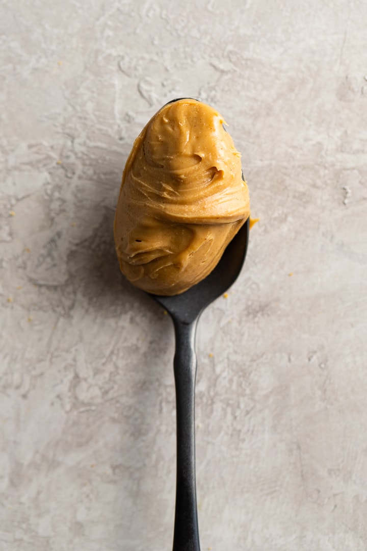 Close-up of creamy peanut butter on a black spoon.