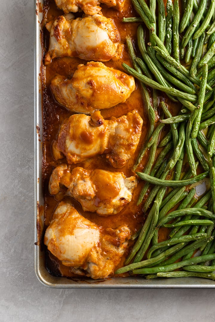 Easy chicken thighs in peanut sauce with green beans, on a sheet pan just out of the oven.