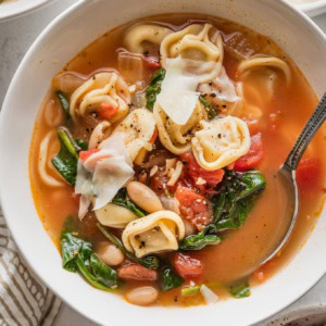 Close up of a bowl filled with white bean tortellini soup.