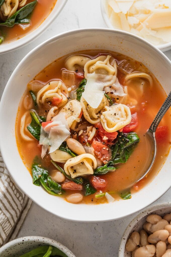Close up of a bowl filled with white bean tortellini soup.