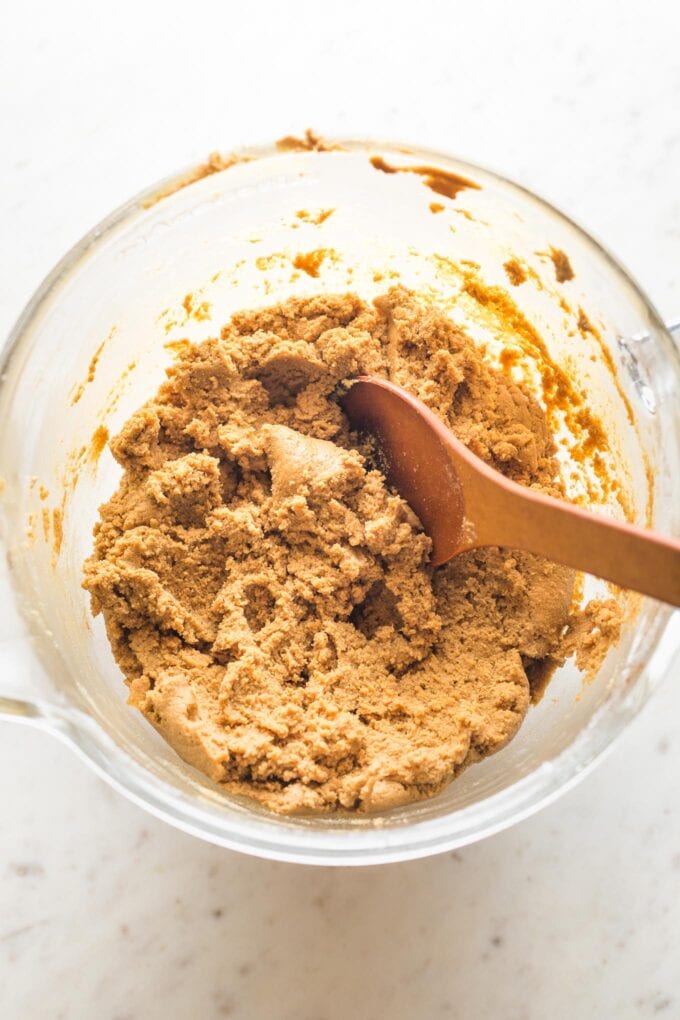 Clear glass bowl with a soft dough for ginger molasses cookies.