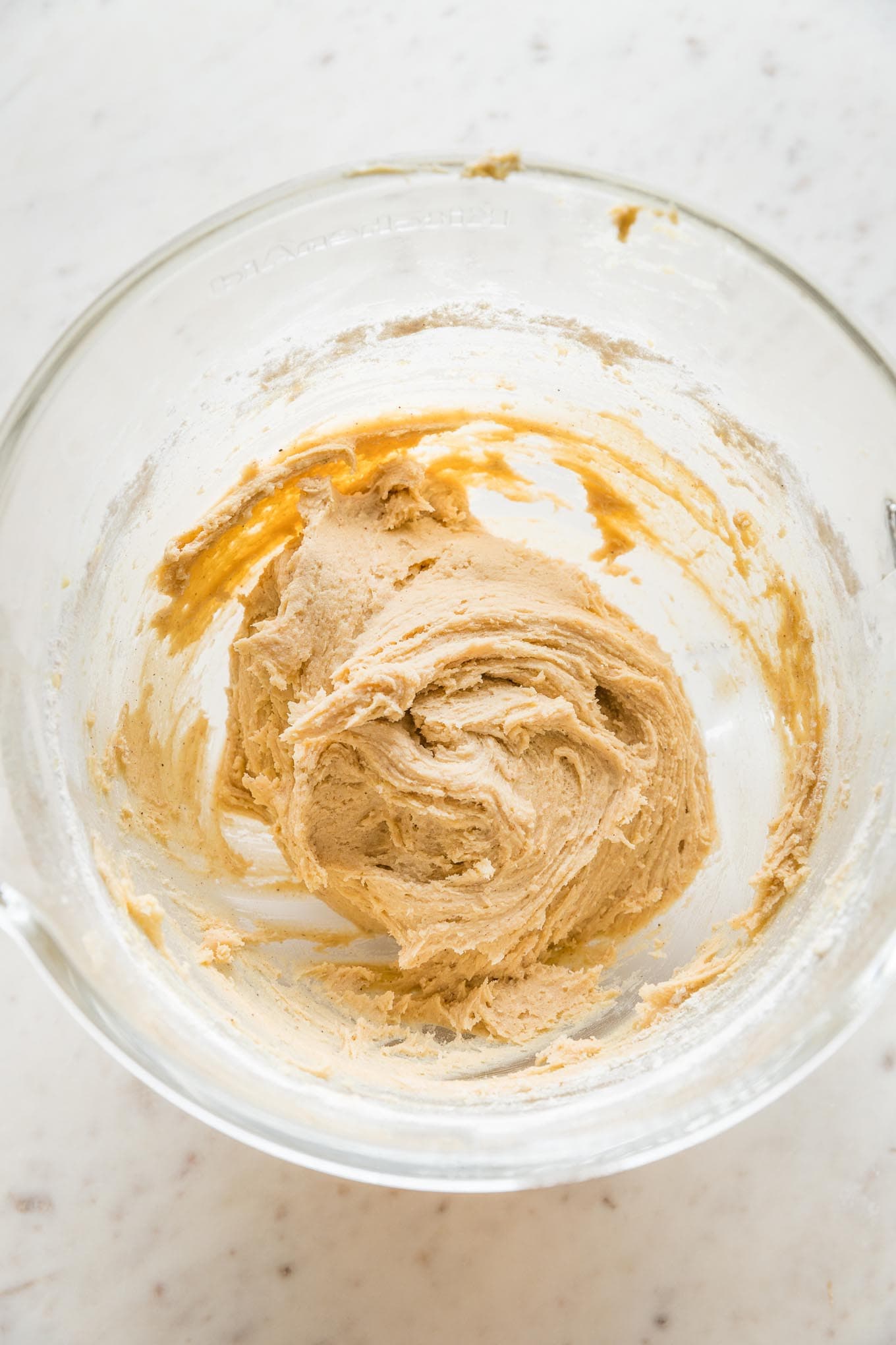 Soft but workable drop sugar cookie dough in a large clear mixing bowl.