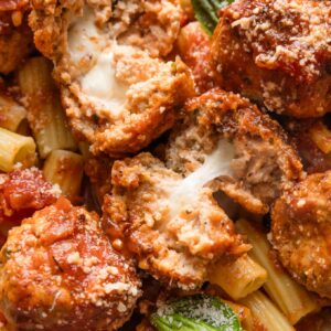 Close up of chicken meatballs stuffed with pockets of molten mozzarella cheese.