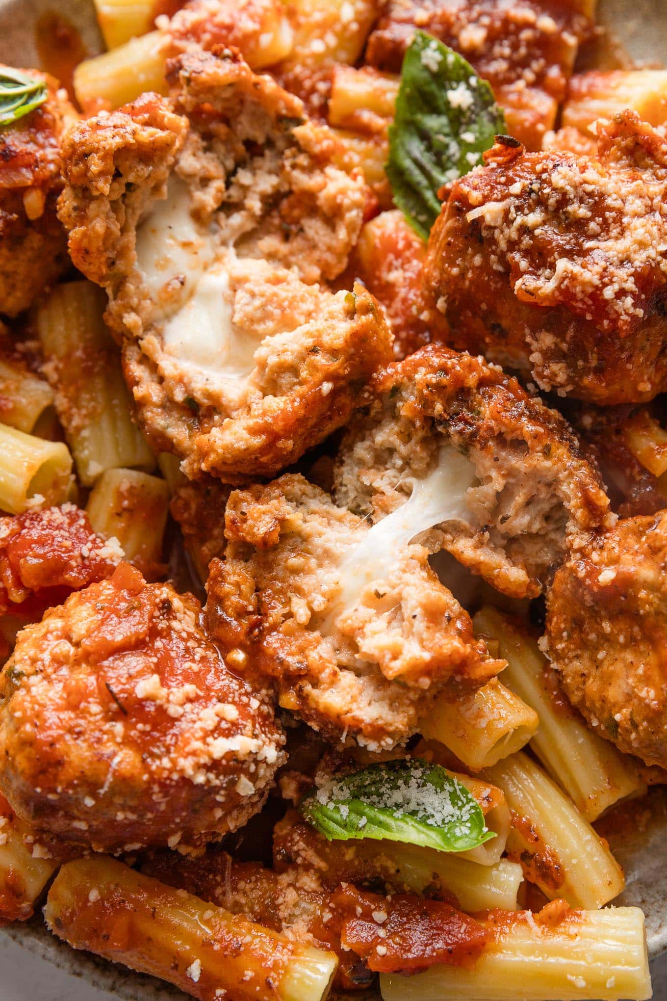 Close up of chicken meatballs stuffed with pockets of molten mozzarella cheese.