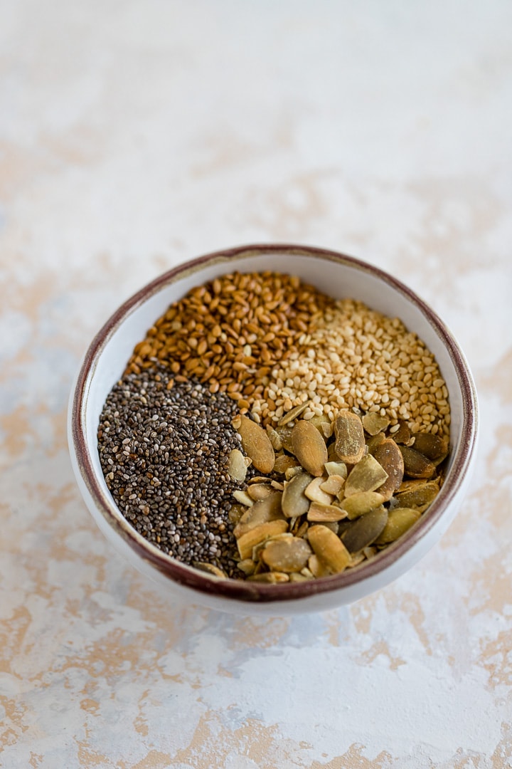 Sesame seeds, flax seeds, chia seeds, and pumpkin seeds in a small bowl.