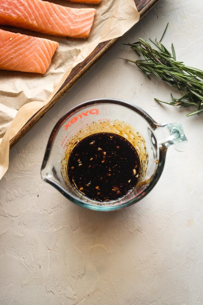 Glaze of pomegranate molasses mixed in a small liquid measuring cup.