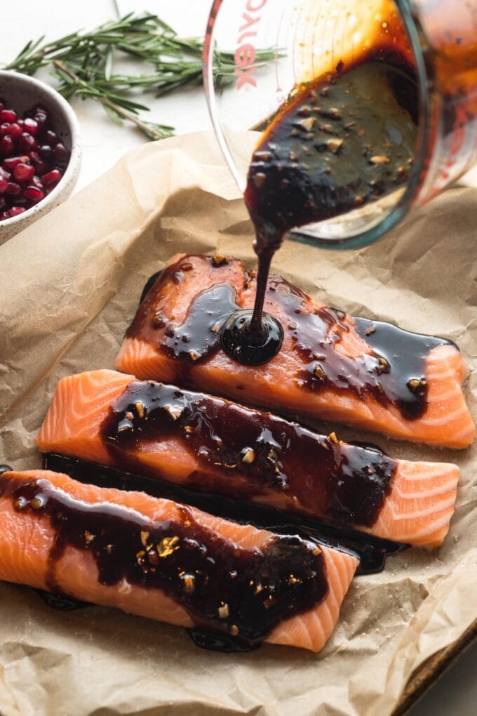 Action shot of glaze being poured onto salmon.