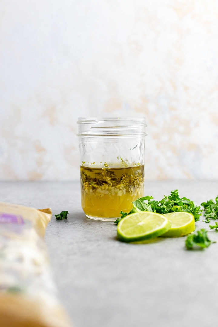 Close-up of a cilantro-lime vinaigrette in a glass jar, ready to shake.