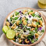 Close-up of a bowl holding cashew coconut slaw with cilantro-lime vinaigrette, made using a Mann's Veggie Blend.