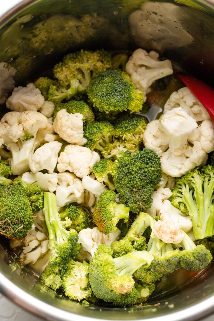 Veggies and seasoning ready to cook in the bowl of an Instant Pot.