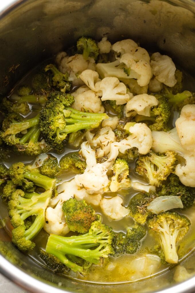 Cooked broccoli, cauliflower, broth, and seasonings in Instant Pot.