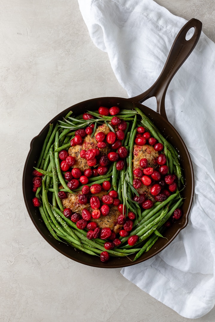 Overhead view of a Marquette Castings cast iron skillet holding balsamic cranberry chicken with green beans.