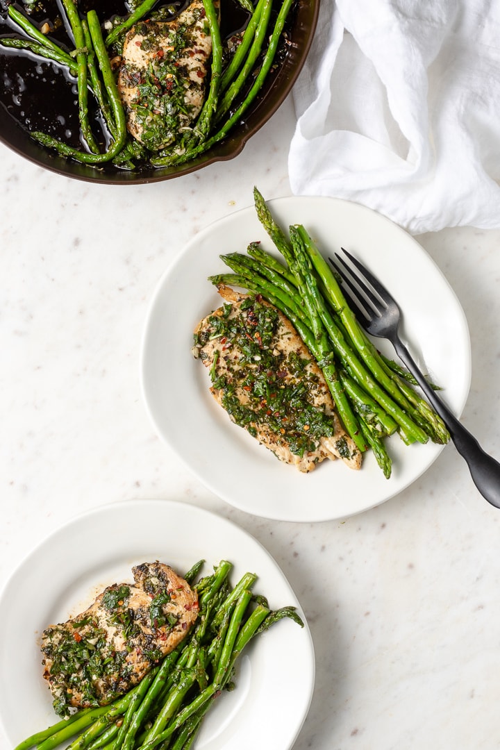 Plated dishes of chimichurri chicken with asparagus.