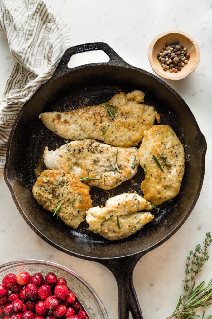 Cooked chicken breasts in a cast iron skillet.