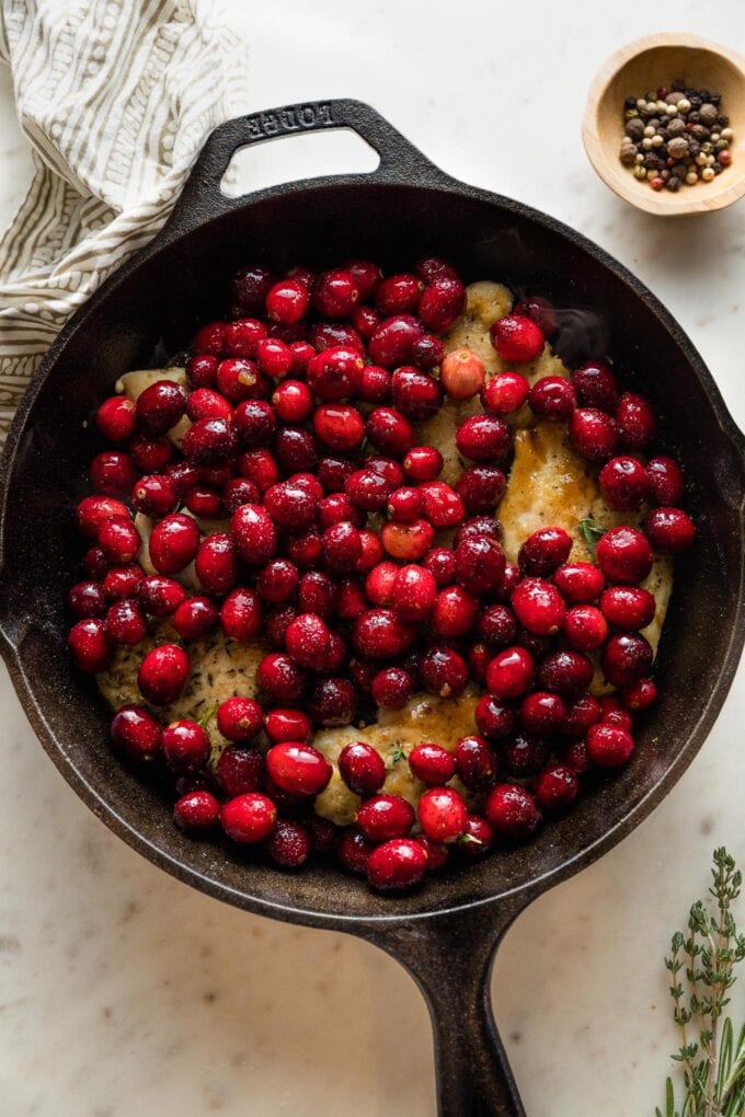 Cranberries poured on top of chicken breasts.