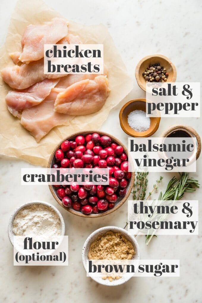 Labeled photo of chicken breasts, fresh cranberries, balsamic vinegar, thyme, rosemary, brown sugar, flour, salt, and pepper in prep bowls.