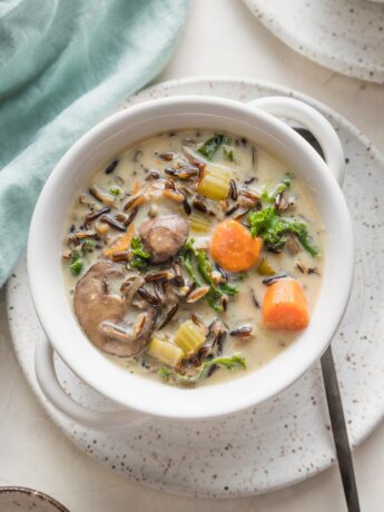 Small ceramic plate and soup bowl filled with a vegetarian wild rice soup made in the Instant Pot.