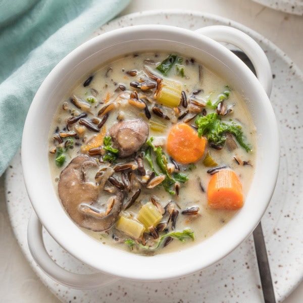 Small ceramic plate and soup bowl filled with a vegetarian wild rice soup made in the Instant Pot.