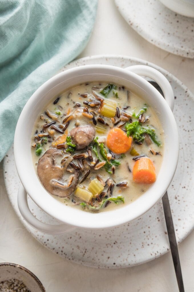 Small ceramic plate and soup bowl filled with a vegetarian wild rice soup made in the Instant Pot.