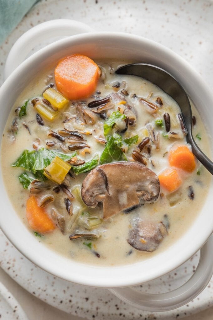 Close up of a spoon in a bowl of Instant Pot wild rice soup.