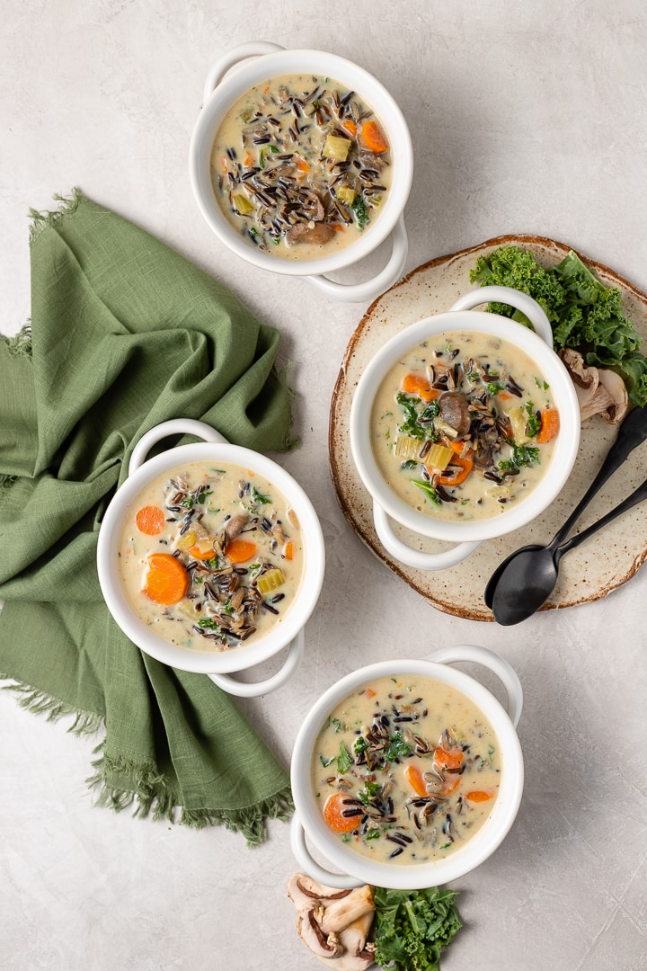 Four white bowls holding Instant Pot wild rice soup.
