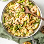 Skillet with lemon asparagus pasta with shrimp and pistachios.