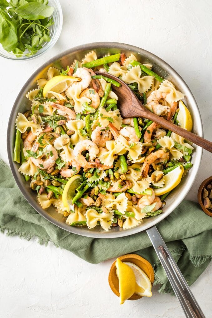 Skillet with lemon asparagus pasta with shrimp and pistachios.