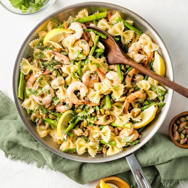 Skillet with lemon asparagus pasta with shrimp and pistachios.