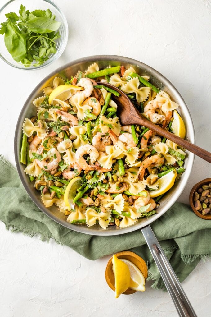 Skillet with lemon asparagus pasta with shrimp and pistachios.