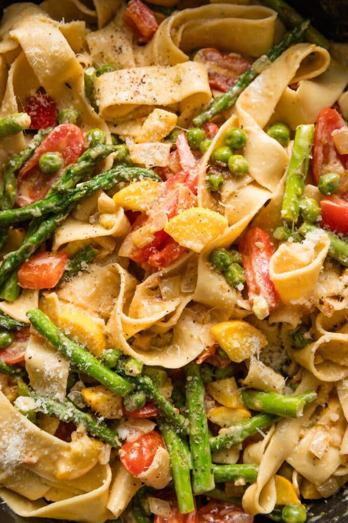 Extreme close up of creamy pasta primavera in a skillet.