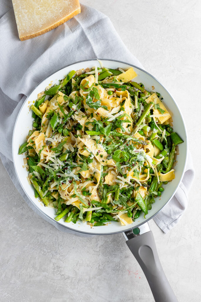 Skillet filled with creamy pasta Primavera.