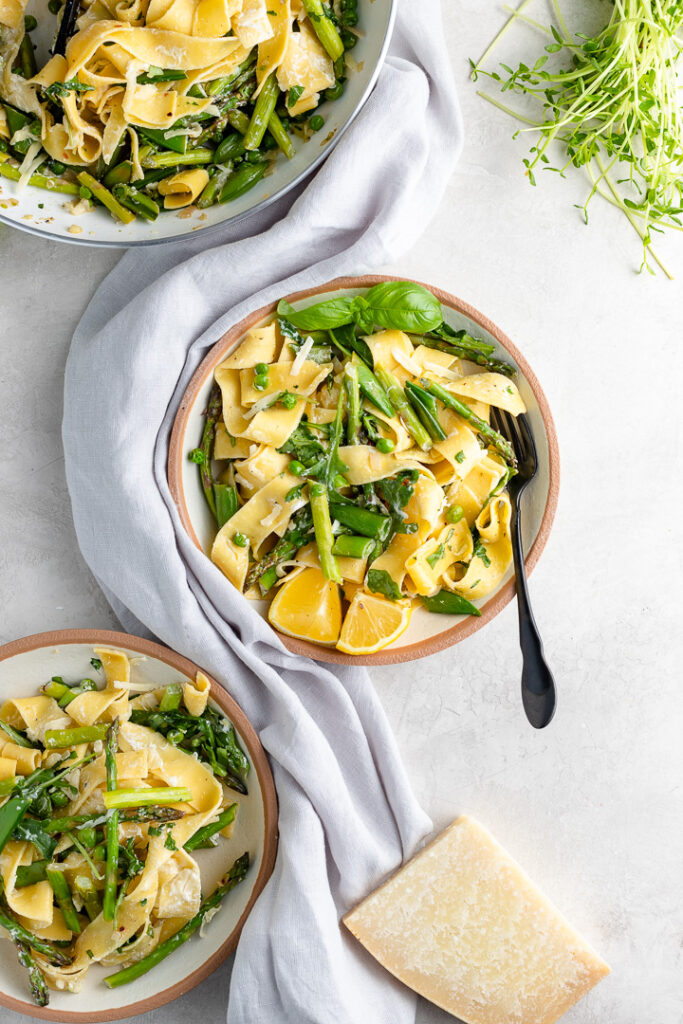 Bowls filled with servings of creamy pasta Primavera.