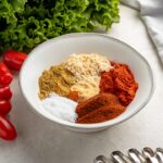 All the spices in homemade taco seasoning arranged in neat piles in a bowl.