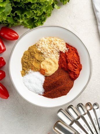 All the spices in homemade taco seasoning arranged in neat piles in a bowl.