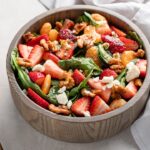 Close up of strawberry spinach salad in a bowl, ready to toss and serve.