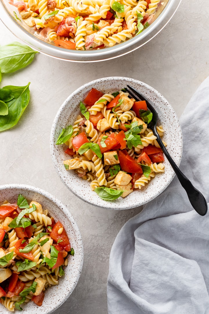 Small bowls filled with Caprese Pasta Salad ready to serve.