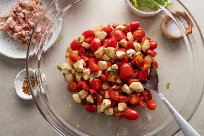 Mozzarella pearls added to prep bowl with tomatoes and basil.
