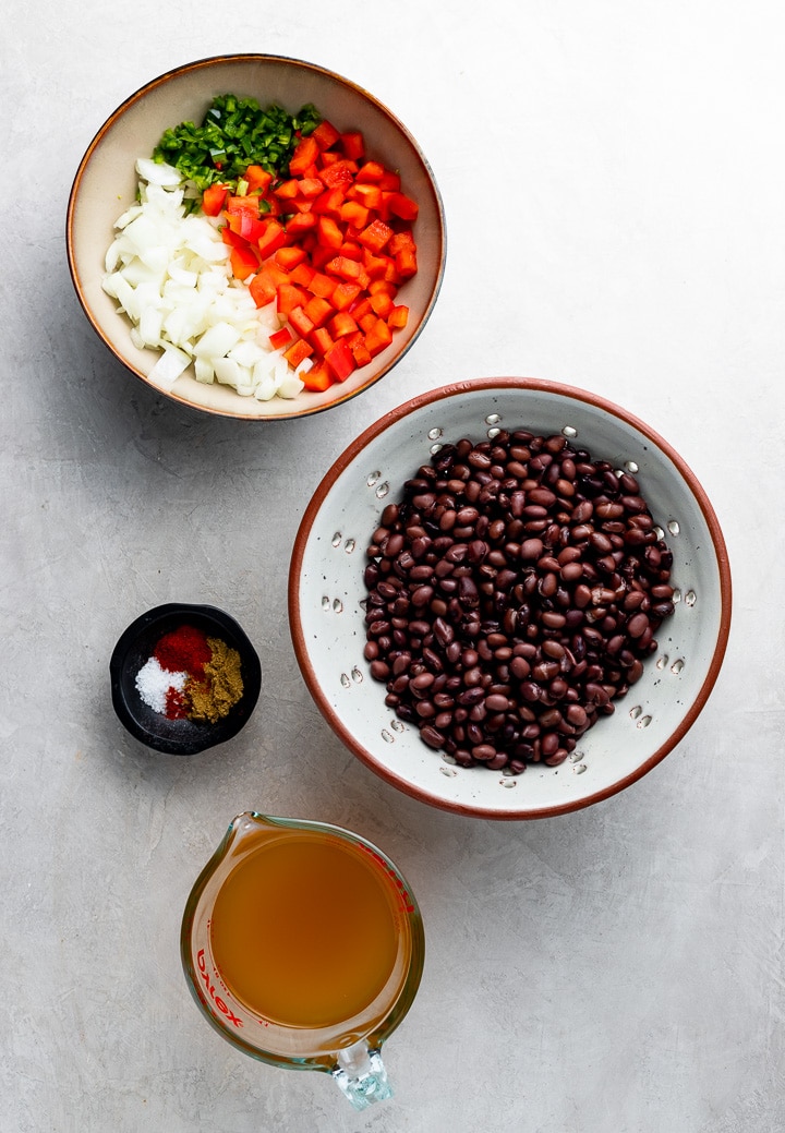 The ingredients for easy spicy black beans: chopped onion, jalapeno, red pepper, canned black beans, chicken or veggie broth, salt and spices.