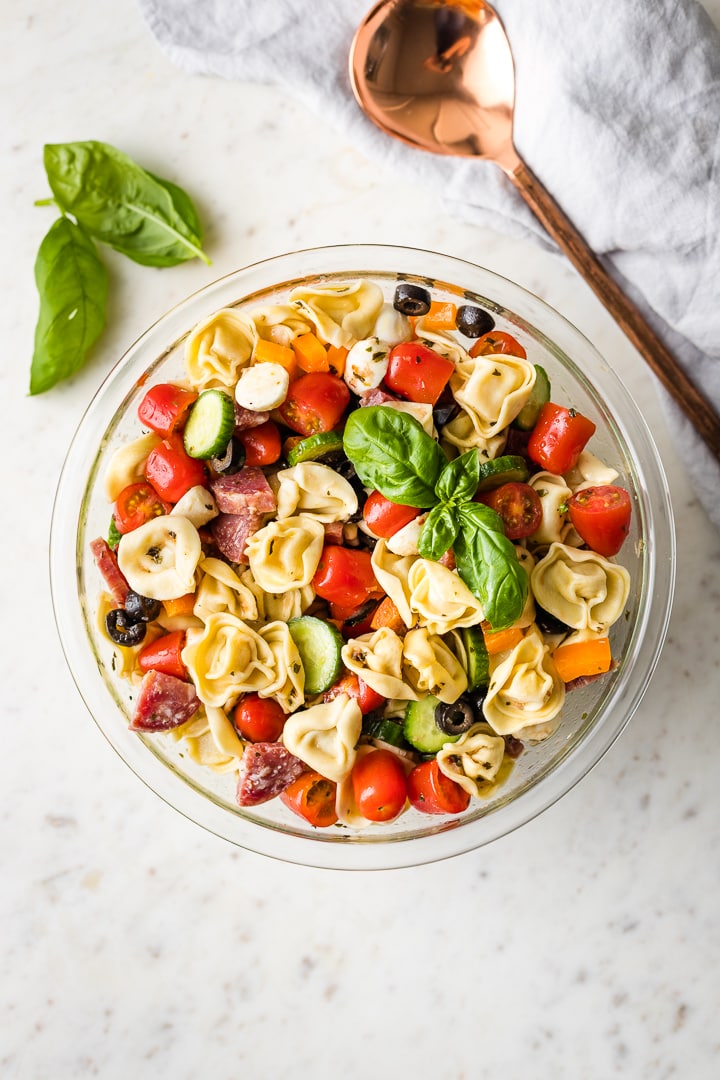 Overhead image of a large bowl and serving spoon ready to dish up some Italian pasta salad.