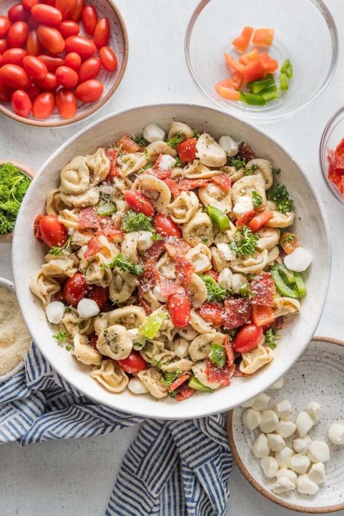 Bowl full of Italian tortellini pasta salad with veggies, pepperoni, and Italian dressing.