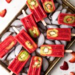 A tray filled with strawberry kiwi popsicles.