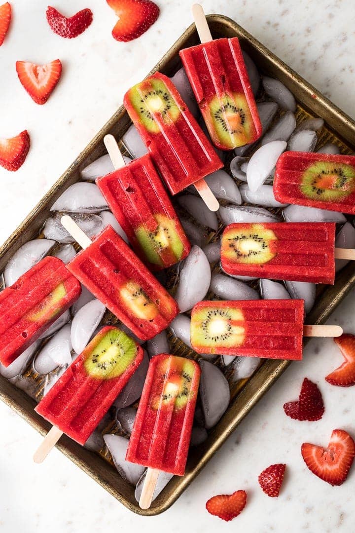 A tray filled with strawberry kiwi popsicles.