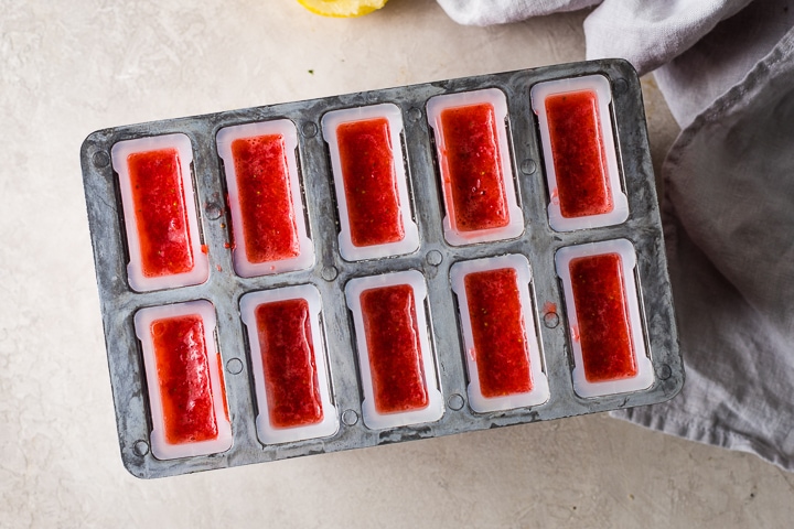 Popsicle molds filled with the strawberry blend.