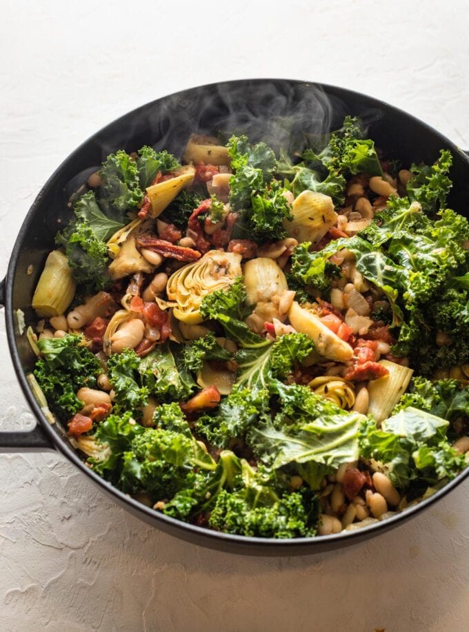 Kale mixed into skillet.