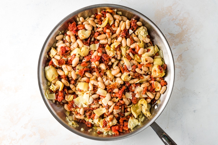Photo of skillet with beans and tomatoes.