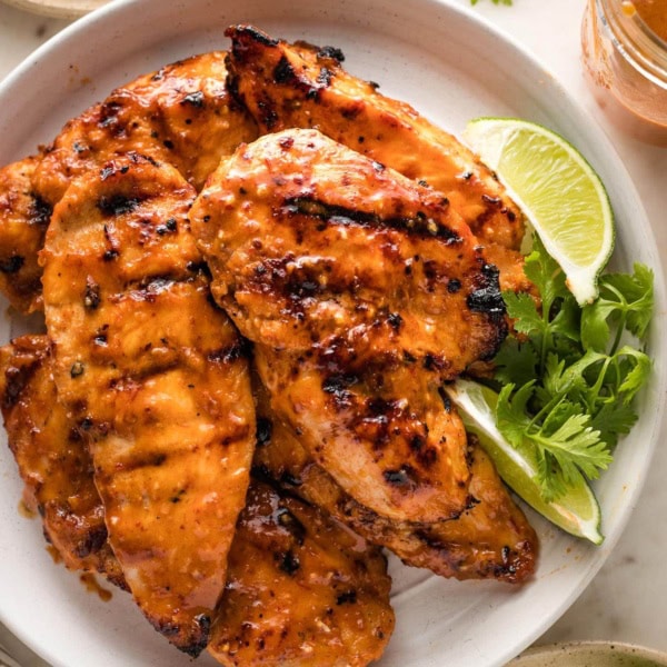 Small plate filled with grilled honey chipotle chicken breasts.