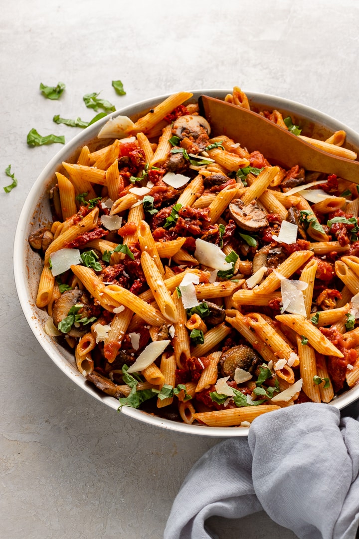 Skillet filled with penne alla vodka with mushrooms and sun-dried tomatoes.